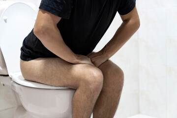 Sitting on toilet with suffering from constipation or hemorrhoid.  Feels uncomfortable in his...