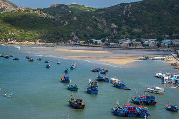 Fototapeta premium Wooden boats and tourist boats are packed close together in the clear blue water of Vinh Hy Bay, Phan Rang, Ninh Thuan.