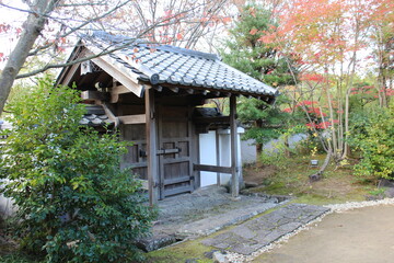 Fototapeta na wymiar Autumn leaves and wooden gate of the Garden of Flowers in Koko-en Garden, Himeji, Japan