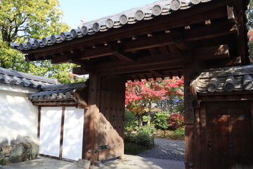 Autumn leaves and wooden gate of Garden of the Lord's Residence in Koko-en Garden, Himeji, Japan (Japanese words written on the wooden tag mean the name of garden "Garden of the Lord's Residence")