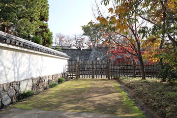 White walls, wooden fence and autumn leaves at Koko-en Garden in the early morning, Himeji, Japan