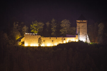 Zamek w Muszynie nocą jesienią. Widok na zamek i okolicę.