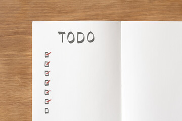 Notebook spread with to-dos written on a wooden desk