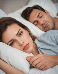 upset woman in bed with her boyfriend snoring