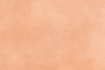 Color of year 2024 peach fuzz. Light coral matte background of suede fabric. Velvet texture of...