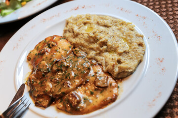Cuisine specialty in Swiss Ticino and Grisons - Polenta Rosso with meat pieces and boletus...