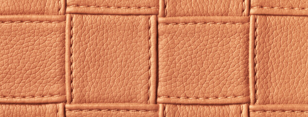 Texture of dark orange and brown leather background with square pattern and stitch, macro.