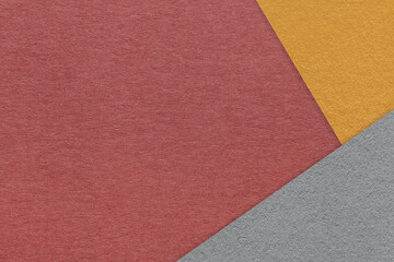 Texture of craft dark red color paper background with orange and gray border. Vintage abstract maroon cardboard.