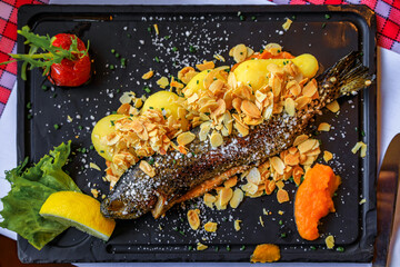 Traditional French trout almondine served with potatoes, salad, carrot puree and a wedge of lemon...