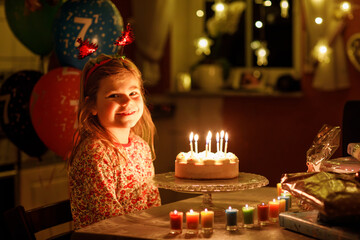 Happy little girl celebrating birthday. Cute smiling child with homemade princess cake, indoor....