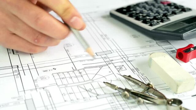 paperwork of floor plan for building, development or planning property. Close-up of blueprint paper on the table. Closeup view of experienced architect drawing blueprints, planning a building.