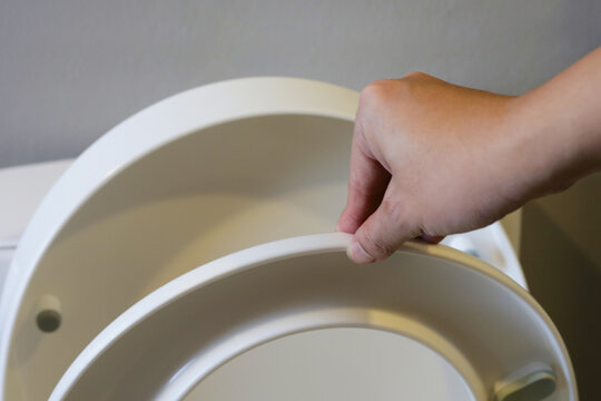 Hand with toilet seat cover
