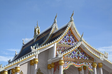 Fototapeta na wymiar Beautiful temple roof against blue sky in Thailand