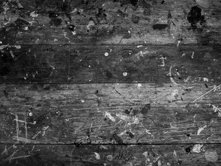Black and white style of wood plank top table covered in color paint splatter. Abstract texture rustic wooden desk background of artist studio with messy colorful paint splash.