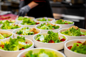 Chef cooking Caesar salad on restaurant kitchen