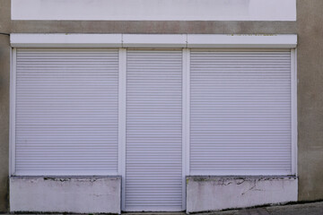 closed store facade with white rolling shutter shop wall entrance