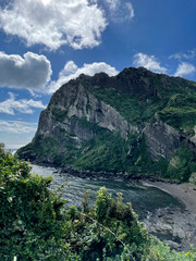 Blue skies, cliffs, grass on rocks, bay