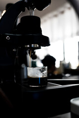 Vertical shot of the Espresso machine making an espresso portafilter directs high-pressure hot...