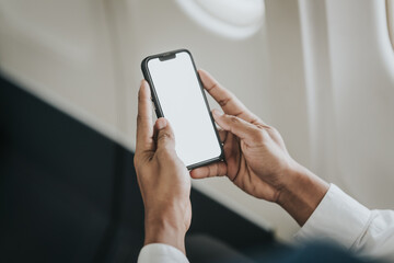 Asian businessman, possibly a stock market trader or investor, focused on his tablet while flying, indicative of a professional managing work on the go.