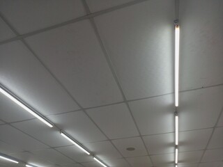 The white ceiling in the building with light long-fluorescent lamps is illuminating