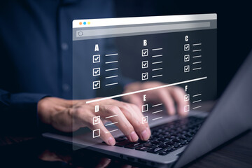 Businessman using a laptop and Taking an assessment, questionnaire, evaluation, online survey online exam Choosing the right answer in exam by filling out the online survey form,Answer  test questions