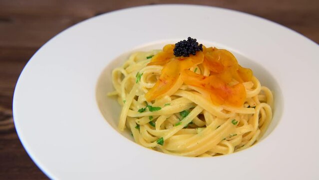 LINGUINE PASTA RECIPE WITH POUTARGUE, LEMON, GARLIC, LEMON ZEST, FRESH CREAM AND PARSLEY. High quality 4k footage