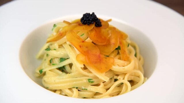 LINGUINE PASTA RECIPE WITH POUTARGUE, LEMON, GARLIC, LEMON ZEST, FRESH CREAM AND PARSLEY. High quality 4k footage