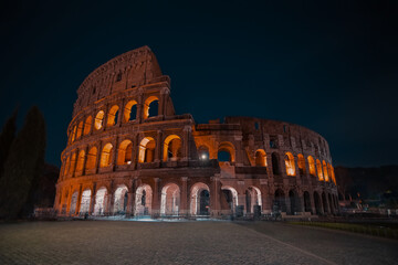 Fototapeta premium Colosseum beautiful view illuminated at night without people. Rome, Italy