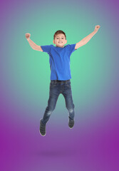 Happy boy jumping on color gradient background