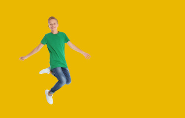 Fototapeta na wymiar Happy boy jumping on golden background, space for text