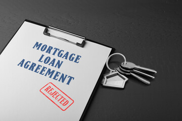 Mortgage loan agreement with Approved stamp and house keys on dark table, closeup