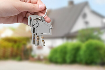 Fototapeta na wymiar Woman holding keys near house outdoors, closeup