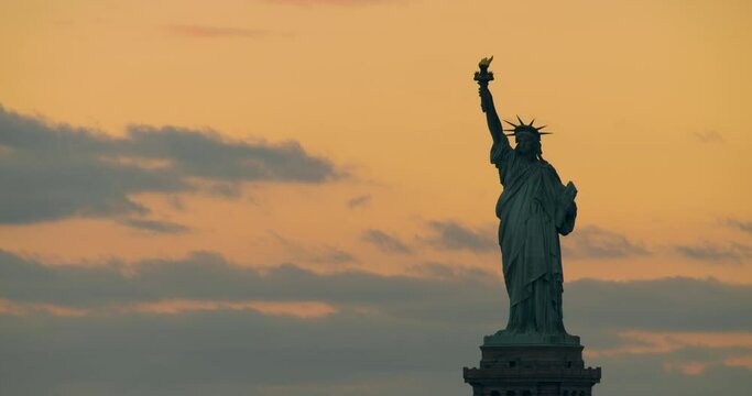 Statue of Liberty in Silhouette Against Orange Sky