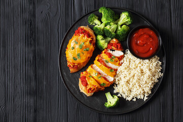 baked chicken breasts with rice, broccoli on plate