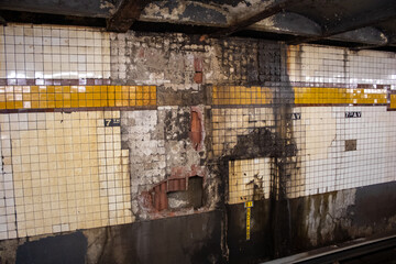 Urban subway station with vintage walls rusting surfaces and broken tiles in Brooklyn, New York