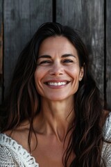 Fototapeta premium A woman with long brown hair smiling at the camera. Perfect for lifestyle blogs and websites