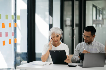 Business team using a calculator to calculate the numbers of statistic business profits growth rate on documents graph data, desk in the office.