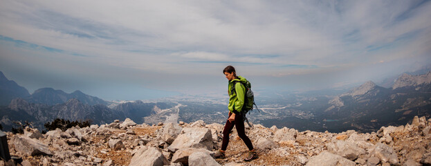 A girl with a backpack on a hike. adventure in the mountains. hiking with a backpack. girl with a...