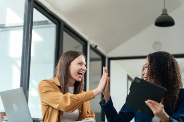 Fototapeta premium Business woman are excited business success with inspiration from their excellent financial results that are happy working in a modern office on a Tablet and computer.