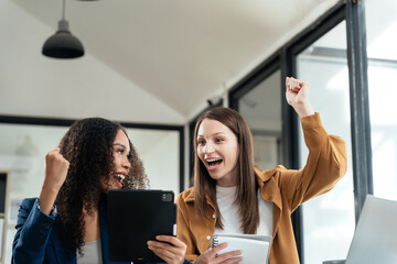 Business woman are excited business success with inspiration from their excellent financial results that are happy working in a modern office on a Tablet and computer.