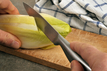 Couper une endive avec un couteau en gros plan