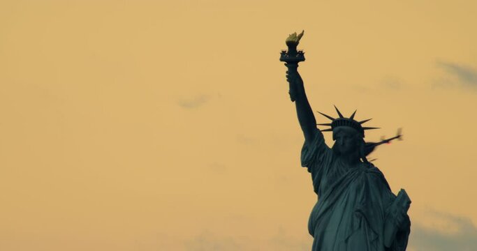 Close-up of Statue of LIberty at Sunset with Helicopter Passing