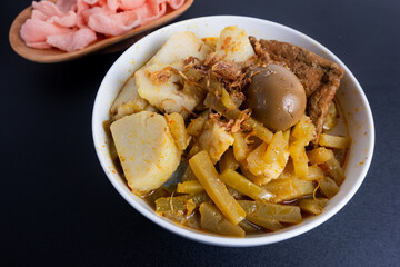 Ketupat Sayur or Lontong Sayur, a typical Indonesian food. Served with pumpkin vegetables, boiled eggs and tofu stew and crackers. Served during Ramadan, Eid al-Fitr and Adha. White Background