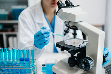 female scientist working with micro pipettes analyzing biochemical samples, advanced science...