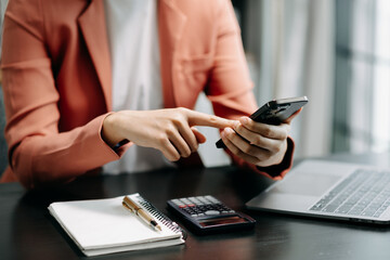 Fototapeta premium business documents on office table with smart phone and digital tablet and graph financial and woman working .