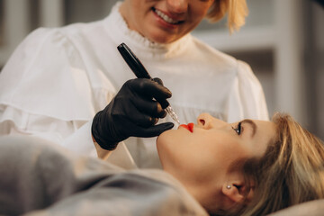 Naklejka premium Permanent Makeup For Eyebrows. Closeup Of Beautiful Woman With Thick Brows In Beauty Salon. Beautician Doing Eyebrow Tattooing For Female Face. Beauty Procedure. High Resolution