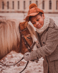 the boy bows his head and listens to the pony