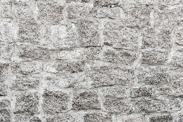 Old light gray stone wall background. Closeup front view of stone wall texture.