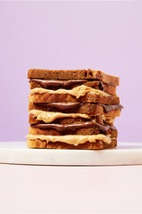 Large, Tall Sandwich with Peanut Butter and Nutella, Close-up on Purple Background