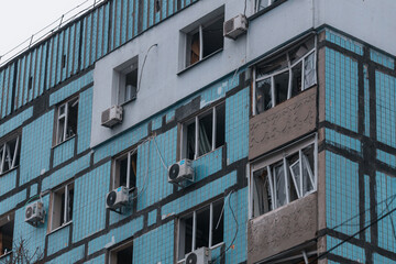 Fototapeta na wymiar Damaged houses after the missile arrived. Broken windows, balconies. Consequences after a strong explosion. War in Ukraine and Russia. Destroyed buildings on the streets of Dnipro